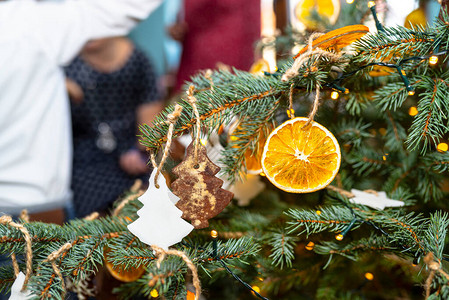 干橙片和树形姜饼挂在圣诞树上图片