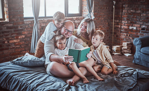 丈夫和妻子及其子女教他们读一本书图片