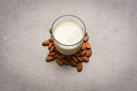 玻璃杯中的杏仁牛奶桌背景图片