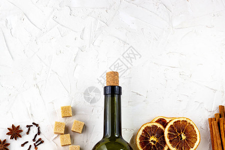 一瓶酒和香料在白色背景上热葡萄酒的成分肉桂八角星橙子红糖丁图片