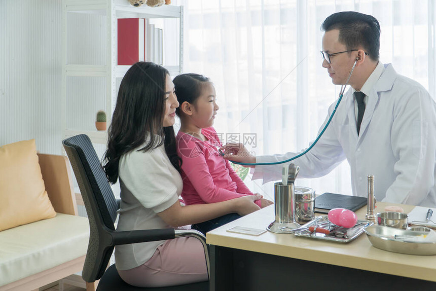 亚洲成年母女在诊所咨询了医生儿科医生通过使用听诊器听心脏对儿童患者图片