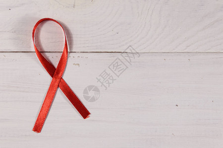 白色木制背景的红色艾滋病丝图片