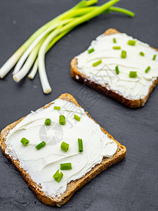 面包片奶油酪和新鲜绿洋葱在黑板早餐小图片