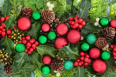 圣诞背景与红色和绿色球摆设装饰和冬青槲寄生常春藤和雪松柏冷杉的传统冬季绿化背景图片