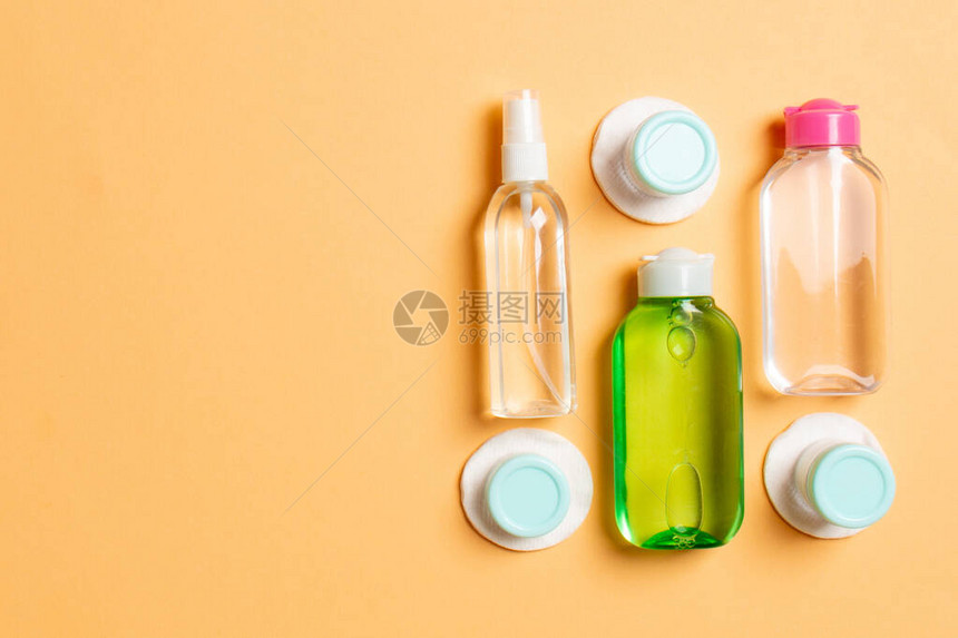 一组用于在彩色背景上旅行的小瓶子为您的想法复制空间化妆品的平躺组合物带化妆棉的奶油图片