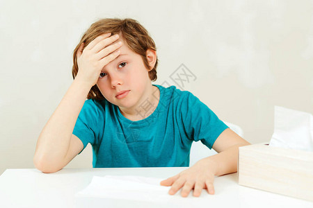 小学生在上课时头疼生病的男孩坐在办公桌前男孩有图片