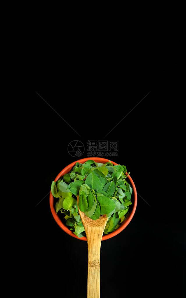 黑背景的木勺子上的花椰叶图片