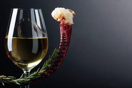 黑色背景的灰色章鱼和白葡萄酒图片
