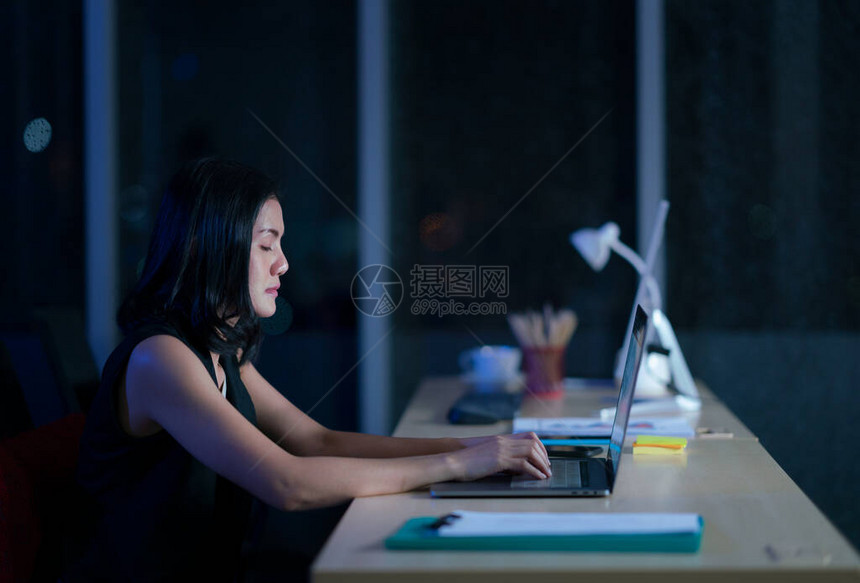 漂亮的商业女在黑暗的办公室里单独工作勤奋图片