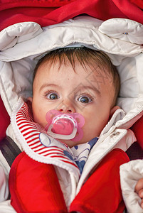 婴儿在摇篮里吸她的奶嘴她的身体被冬图片