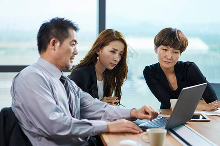 使用膝上型计算机在办公室开会的三名亚洲公司执行官男女用笔记本图片