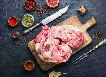 桌上的一大块猪肉和一把肉刀图片