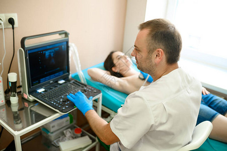 男乳房科医生在诊所进行乳房超声扫描图片