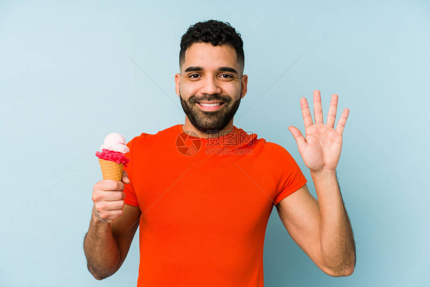 年轻拉丁男子拿着冰淇淋孤立地微笑着快乐的笑容展图片