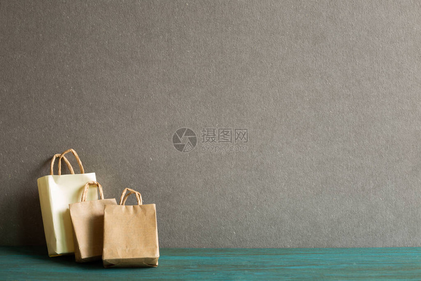 灰色背景木桌上的牛皮纸购物袋图片