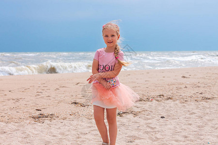 独自在空荡的海滩上行走蓝天背景的美丽的小公主快乐可爱的孩子跑孩图片