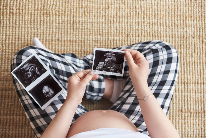 持有超声图像的孕妇的顶视图怀孕保健妇科医学的概念等待婴儿的年轻母亲特写镜头图片