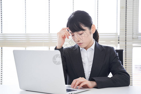 一位在操作笔记本电脑时处境困难的日本图片