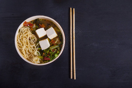 日本豆腐汤面条蔬菜和草药黑底的竹图片