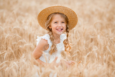 穿着草帽的可爱小女孩在阳光温暖的背景图片