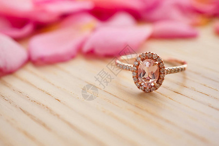 木桌上的粉红宝石钻环漂亮的玫瑰花图片