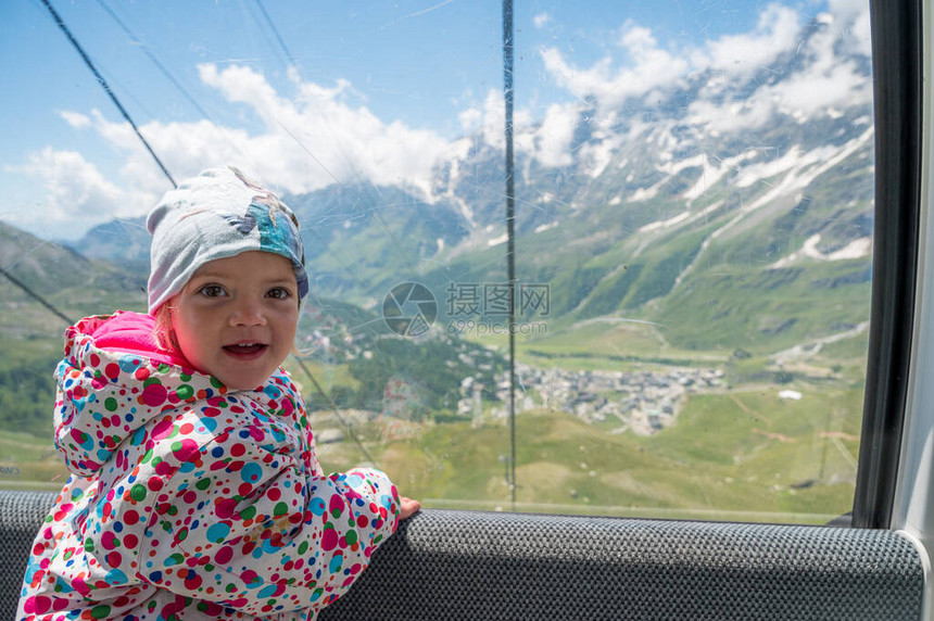 快乐的女孩享受着搭山电梯的旅程意大利CerviniaBreuil上方图片
