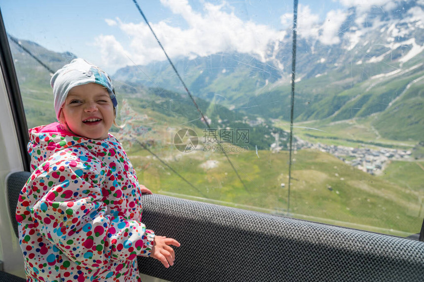 快乐的女孩享受着搭山电梯的旅程意大利CerviniaBreuil上方图片