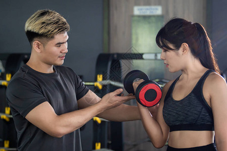 重量训练教训初学者徒进行肌肉锻炼健身私人教练建议女背景图片