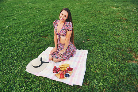 美丽的年轻女子在绿色公园享受美好一天健康营养水果零食时图片