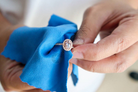 使用微型纤维织物来打磨和清洗珠宝首饰钻石环的珠图片