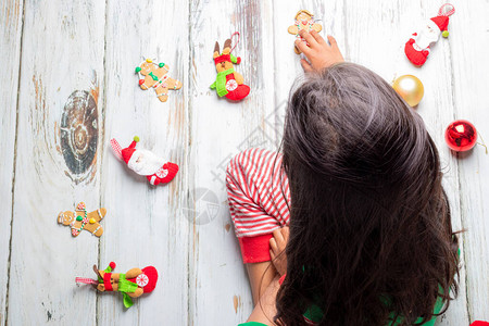 有圣诞睡衣的小女孩玩着圣诞装饰图片