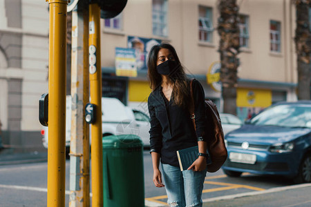 城市街道上戴口罩的年轻女子图片