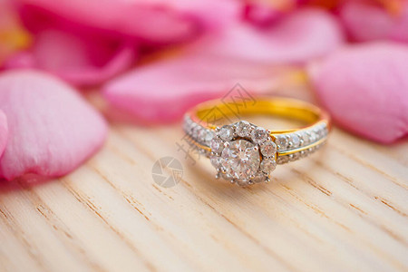 木桌上的珠宝钻石戒指漂亮的粉红玫瑰花图片