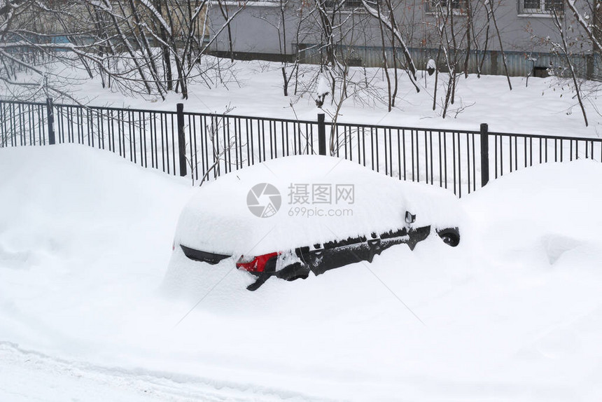 这辆车几乎完全被雪覆盖在围栏前面的院子图片