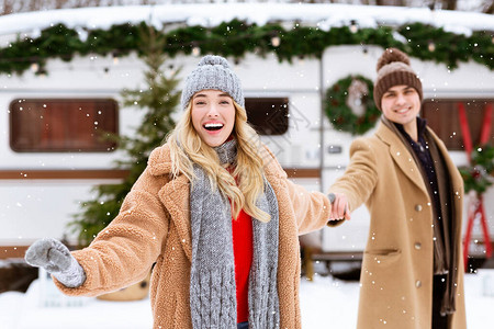 快乐的女孩带领她快乐的男朋友在Capside的冬日户外观看降雪图片
