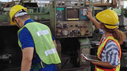 一群工厂人在工厂车间使用机器设备工图片