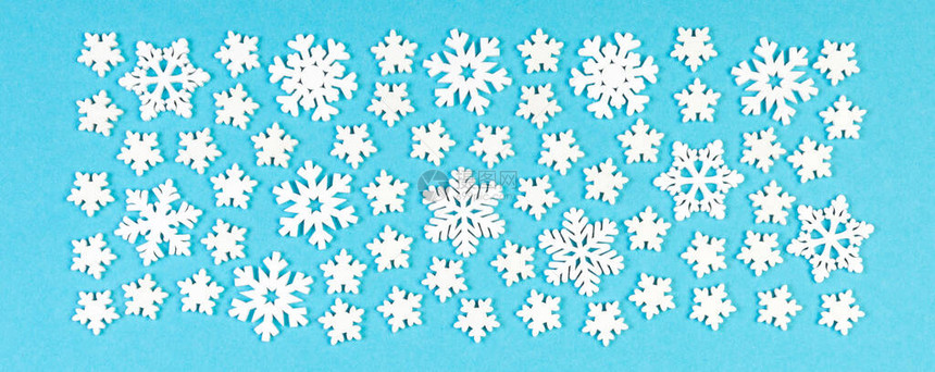 在多彩背景上的一组白雪花圣诞装饰品的顶部视图用于设计的新年时间图片