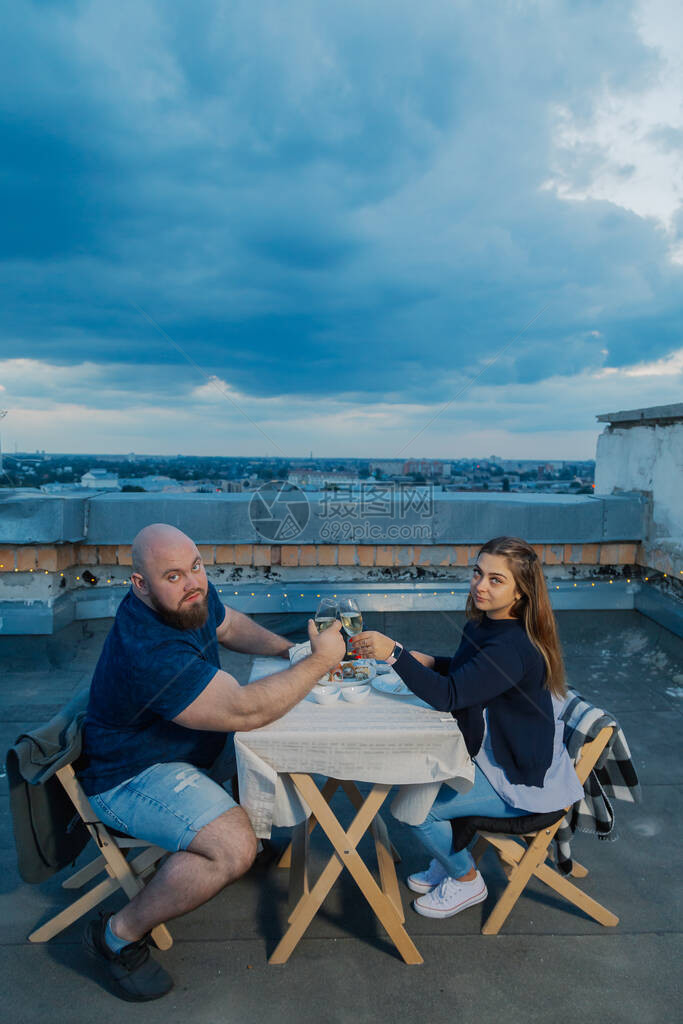 屋顶上的恋人坐在桌旁图片