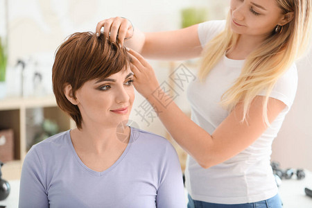 专业理发师在美容沙龙与年轻图片