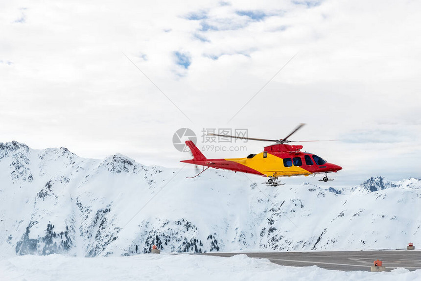 山地滑雪救生直升机从车站直升机停坪起飞图片
