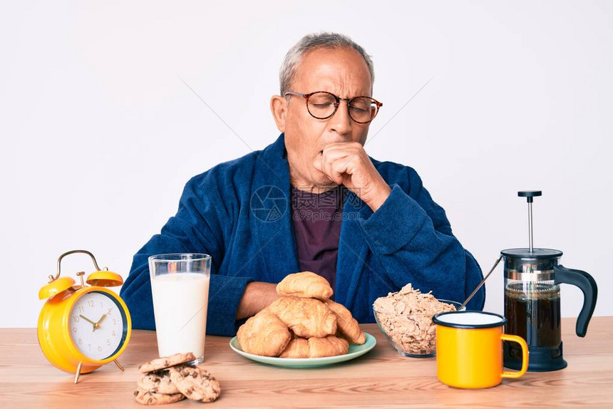 早上坐在桌子上吃早餐的白发帅哥感觉不适图片