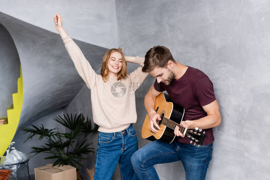 男人演奏音乐吉他接近快乐的女人用图片
