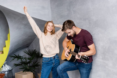 男人演奏音乐吉他接近快乐的女人用图片