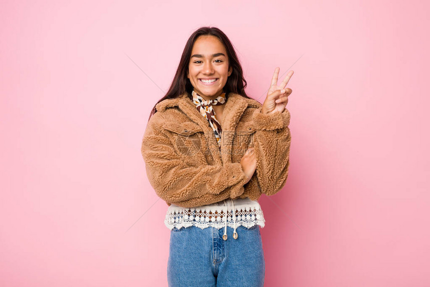 身穿短绵羊皮大衣的印度裔年轻混血女子用手指图片