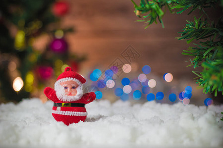 圣诞老人娃放在雪上圣诞树背景上还图片