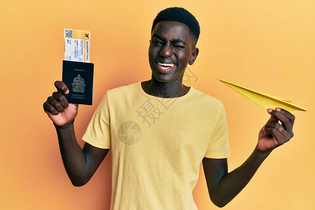 年轻非洲人拿着纸机和护照图片