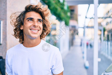 年轻英俊的西班牙人笑着快乐地在城图片