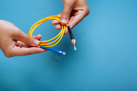 女手握着SC和FC连接器纤维光纤线条图片