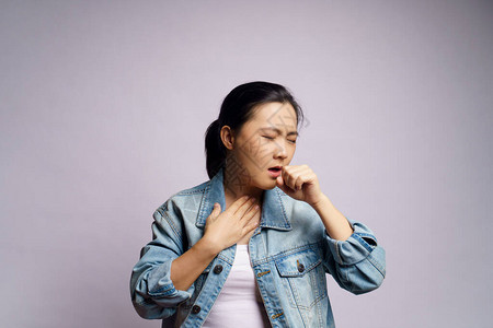 亚裔妇女因发烧咳嗽打喷嚏和在白种背景上图片