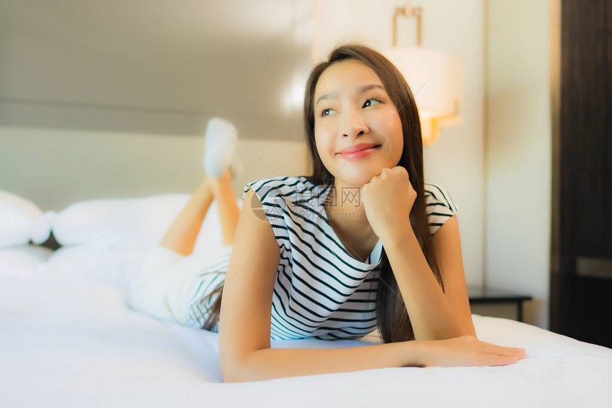 美丽的肖像年轻的亚洲女在卧室内卧图片